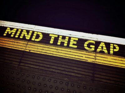 A picture of the edge of the train platform in the London Subway where it says Mind the Gap