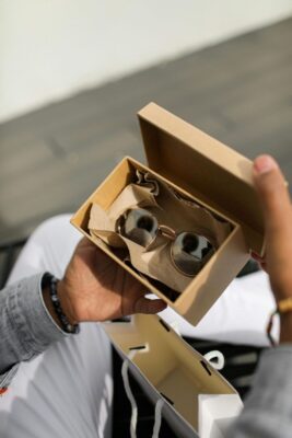 A pair of sunglasses in a box held in a person's hands.