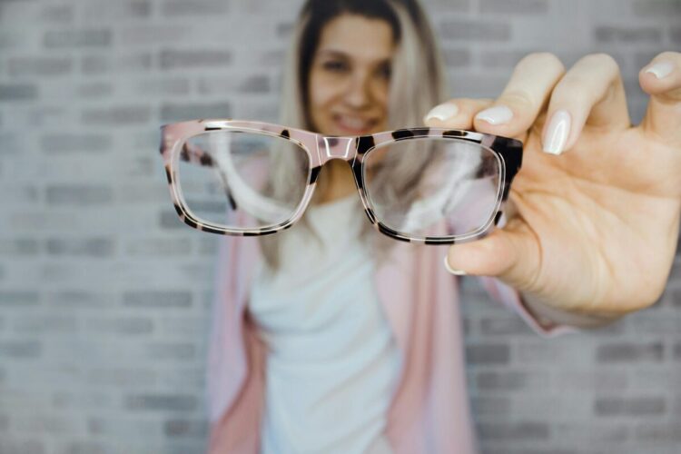 Woman looking through a pair of glasses